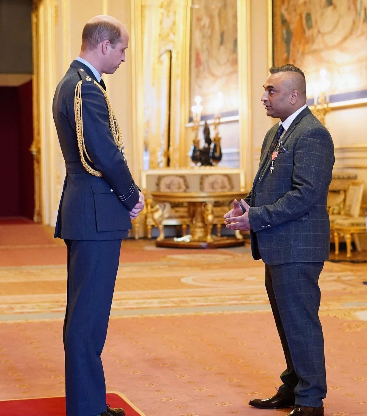 The Queen honoring Mr Sanjeev Kumar at Buckingham Palace.
